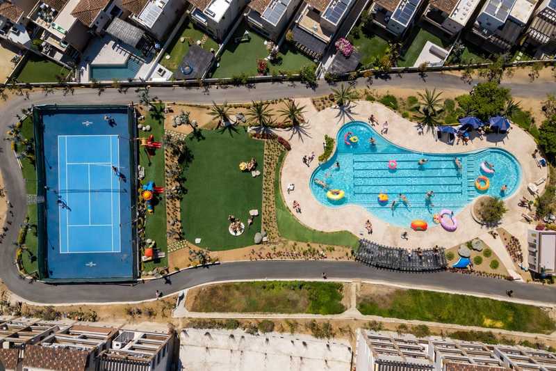 Aerial view of pool, tennis courts, and playground at El Tezal vacation rental in Cabo San Lucas